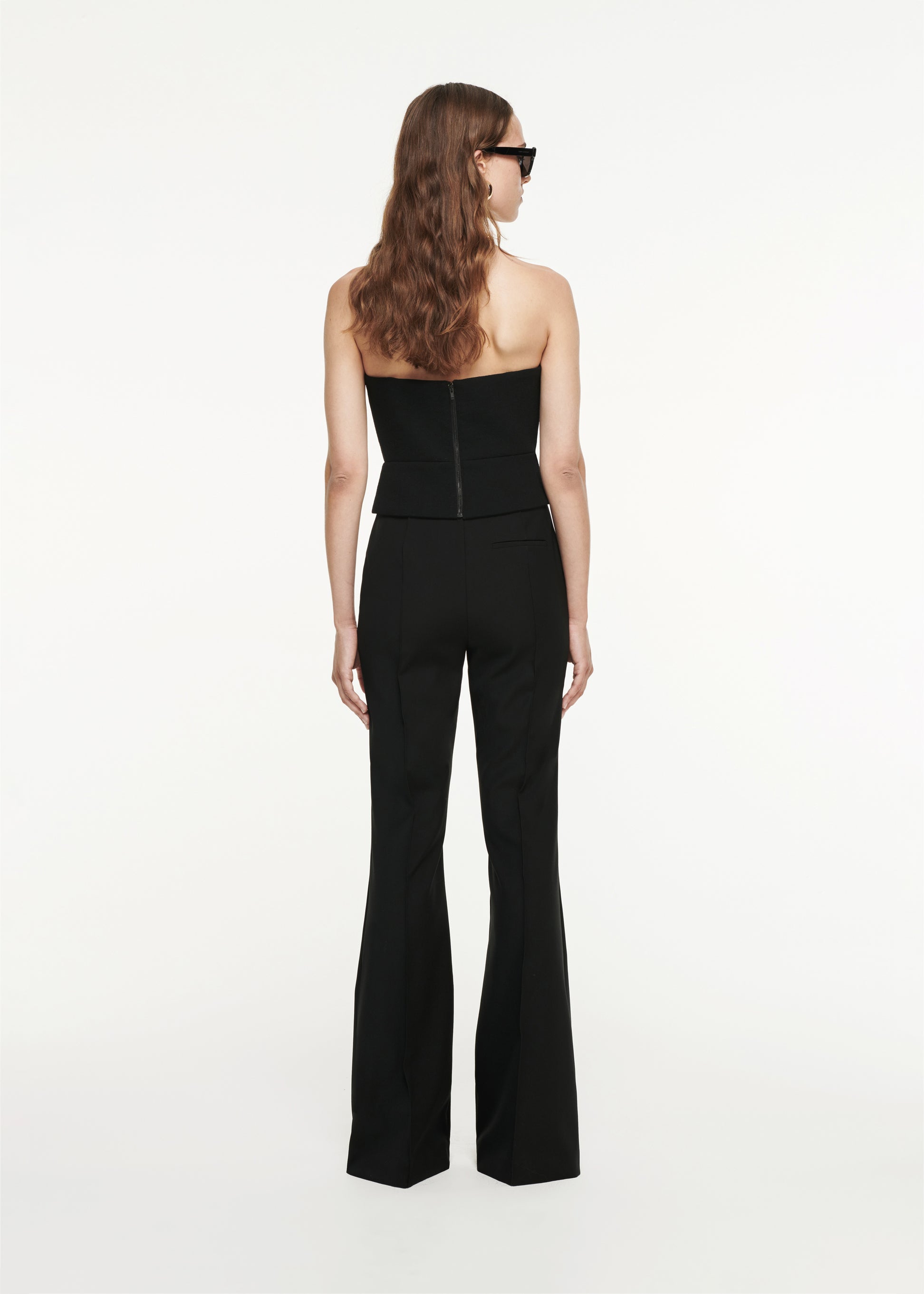 The back of a woman wearing the Flared Wool Trouser in black