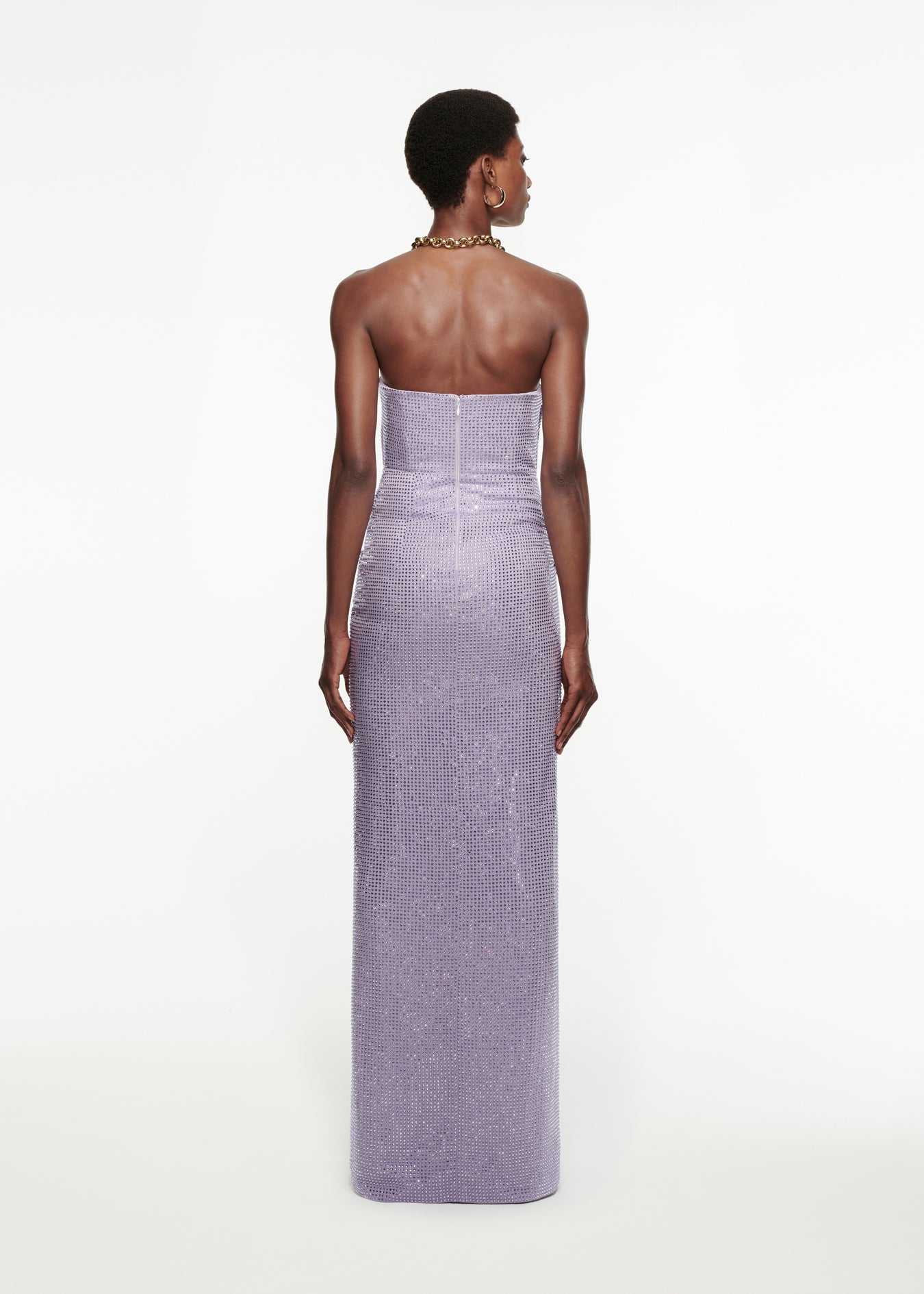 The back of a woman wearing the Asymmetric Diamanté Gown in Lilac