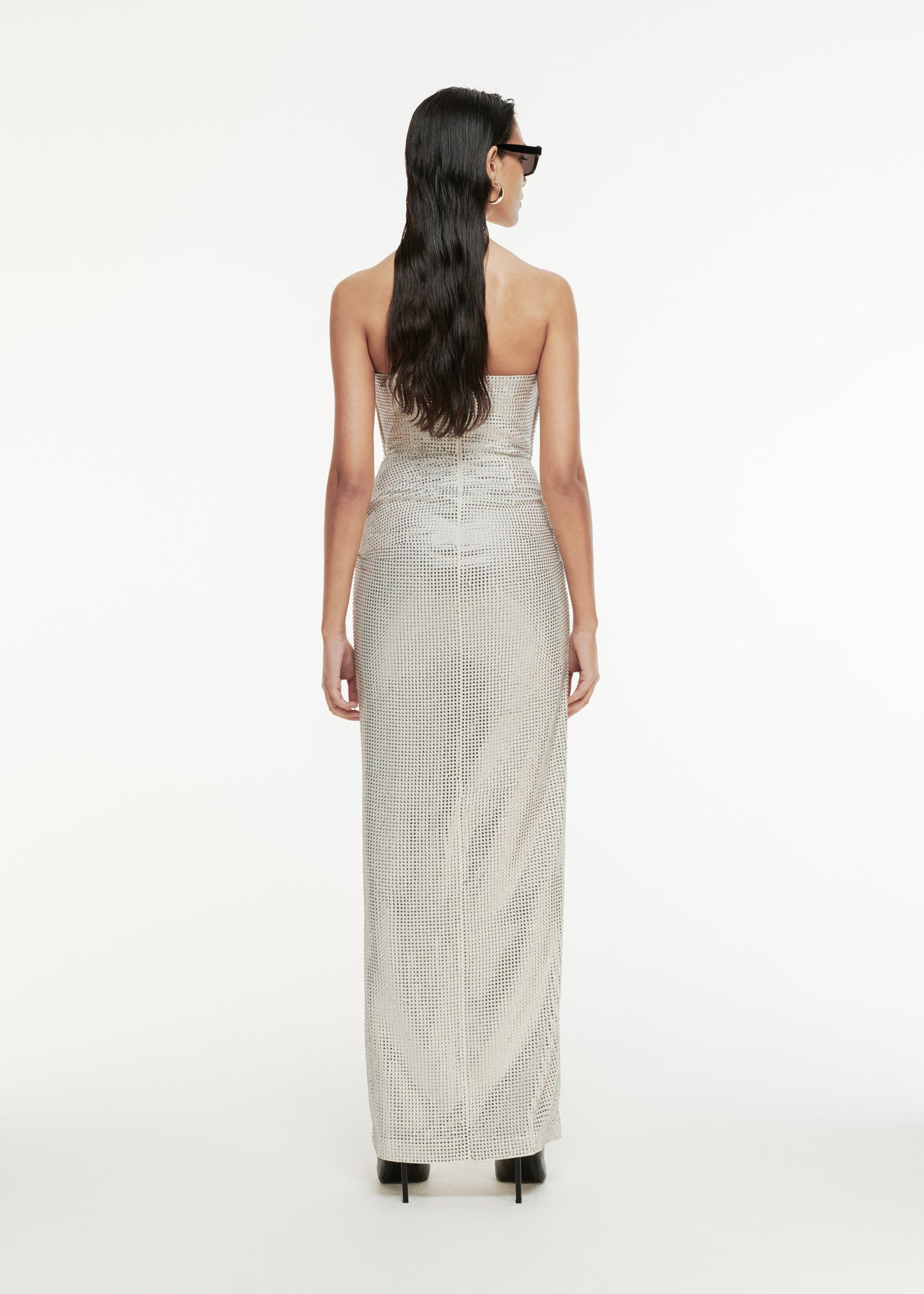 The back of a woman wearing the Asymmetric Diamanté Gown in White