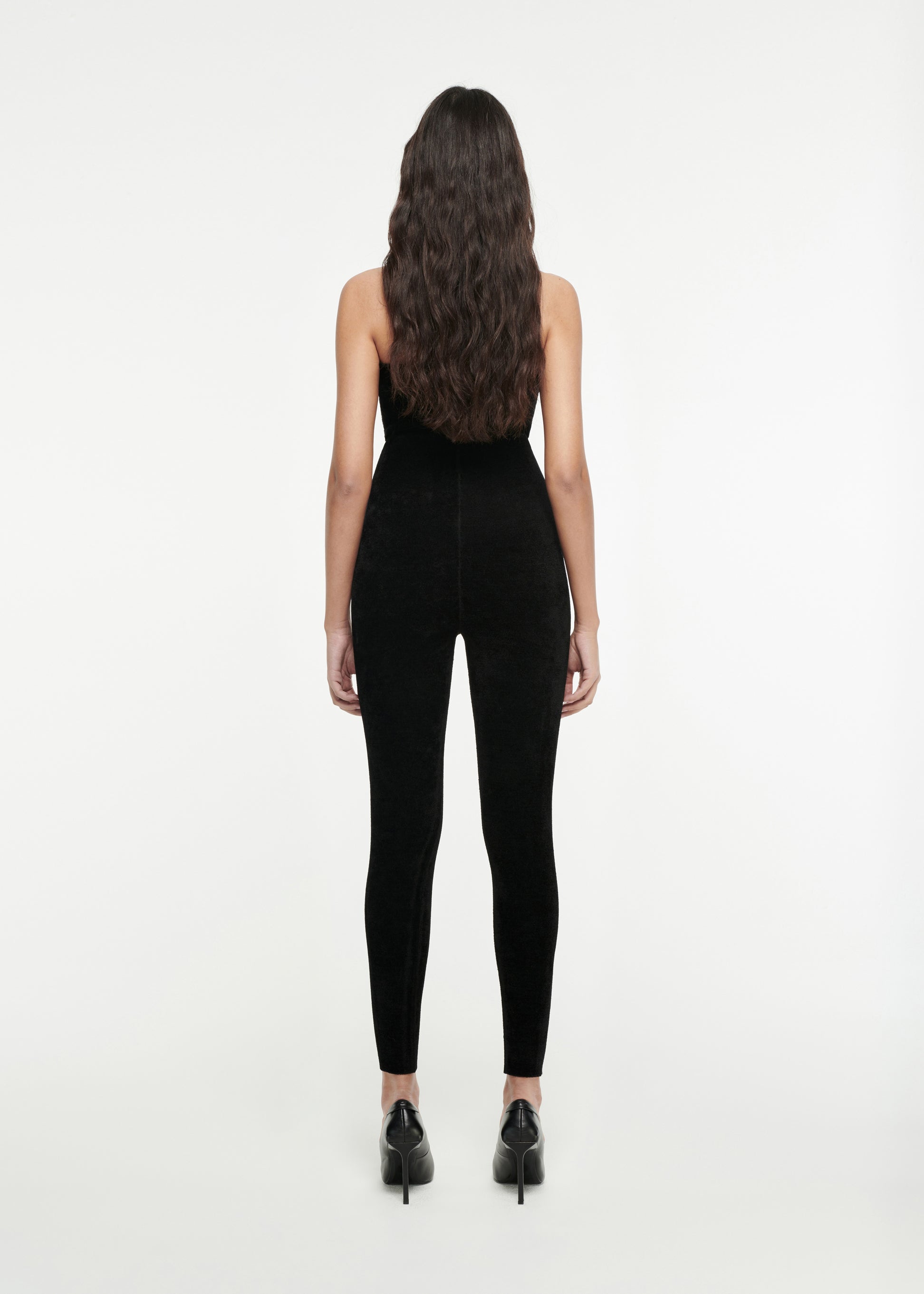 The back of a woman wearing the Strapless Chenille Knit Jumpsuit in Black