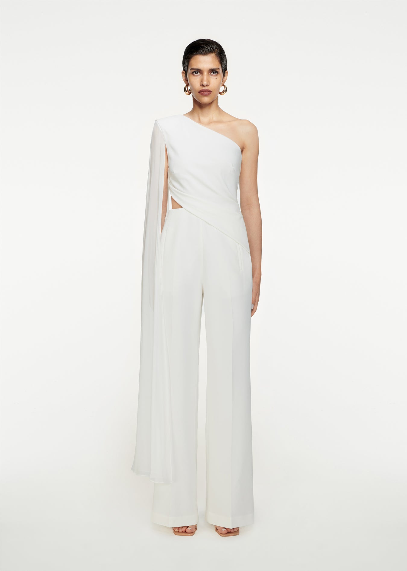 Woman wearing the Asymmetric Stretch-Cady Cape Jumpsuit in White