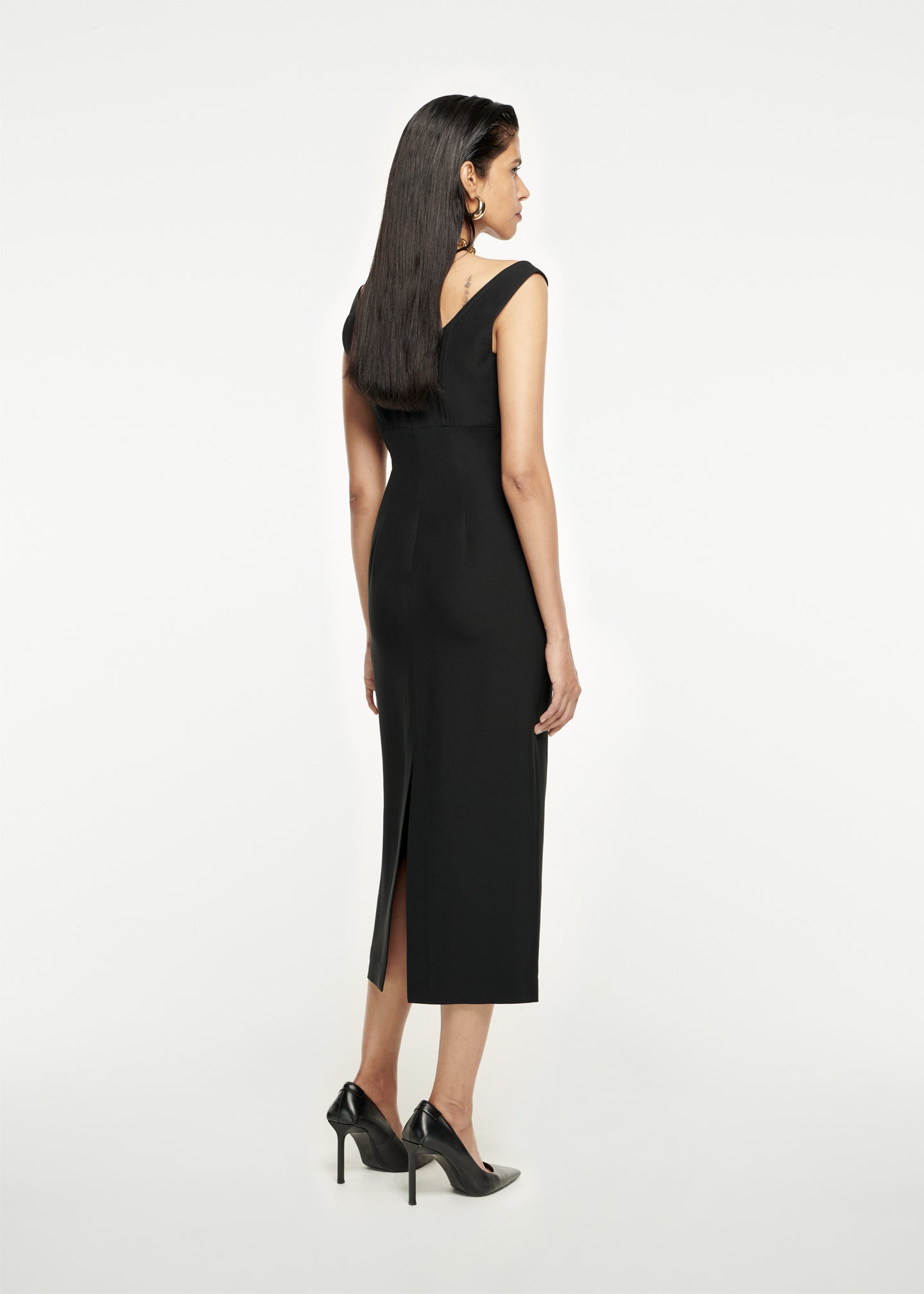 The back of a woman wearing the Off The Shoulder Silk Wool Midi Dress in Black