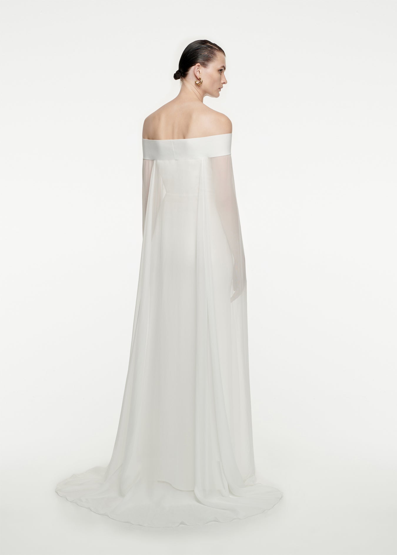 The back of a woman wearing the Off The Shoulder Stretch-Cady Gown in White