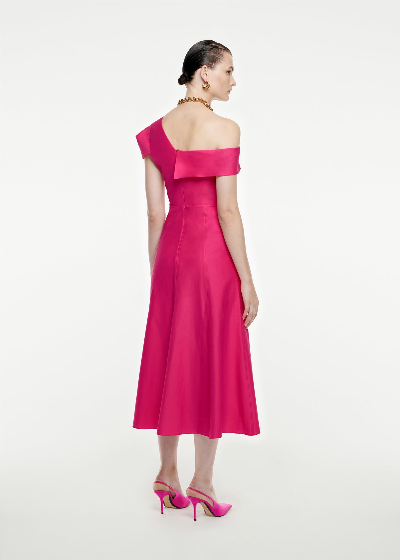 The back of a woman wearing the Asymmetric Cotton Poplin Midi Dress in Pink