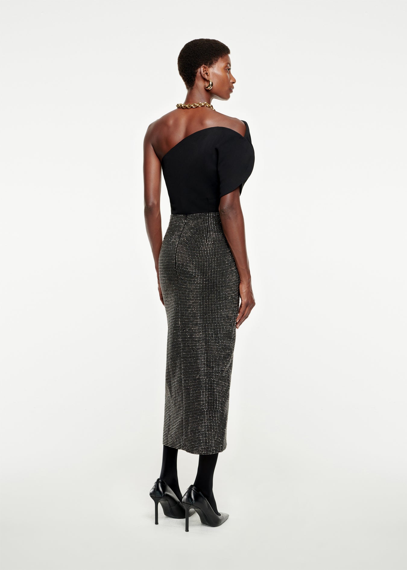 The back of a woman wearing the Diamante Midi Skirt in Black