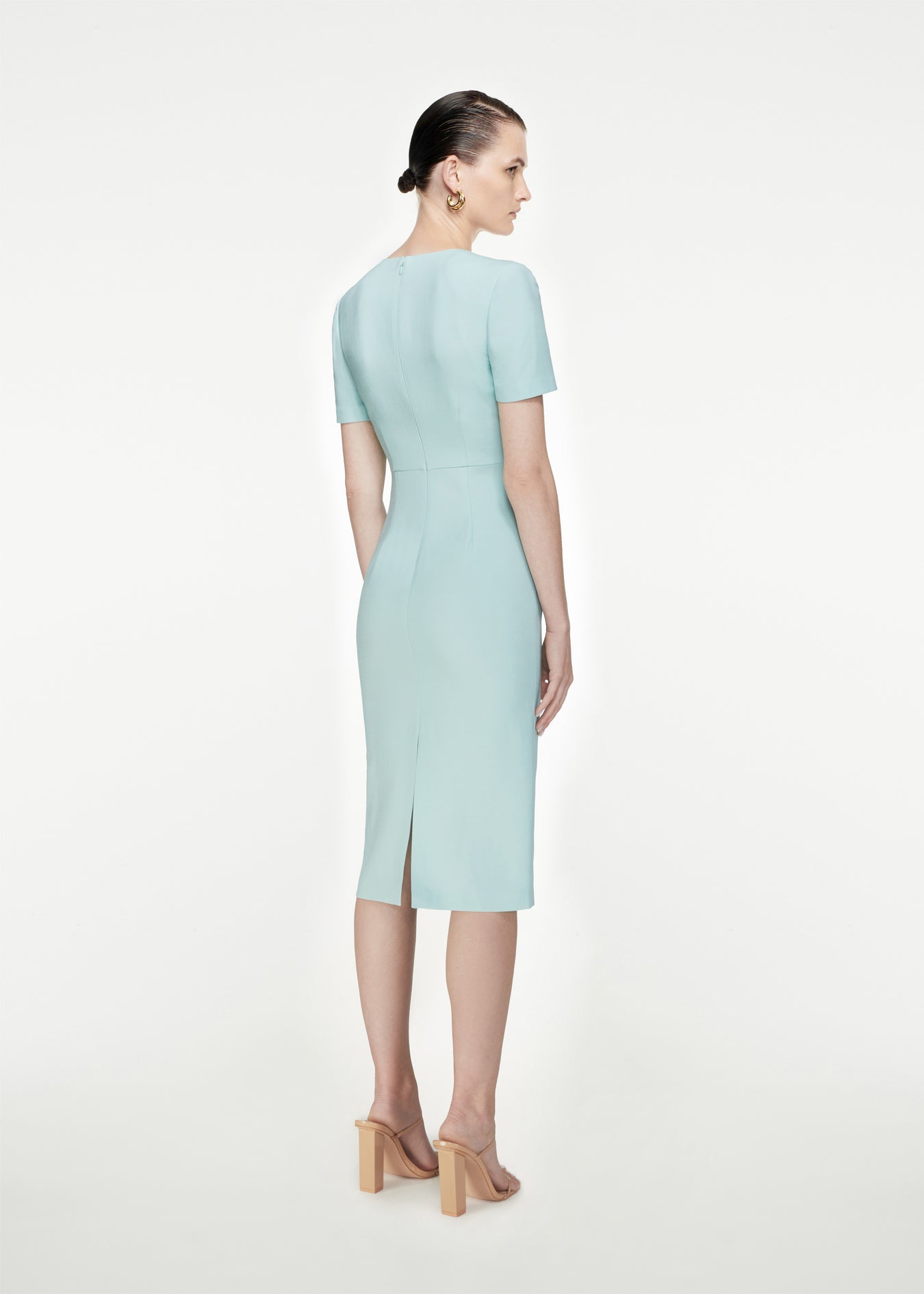 The back of a woman wearing the Short Sleeve Silk Wool Midi Dress in Light Blue
