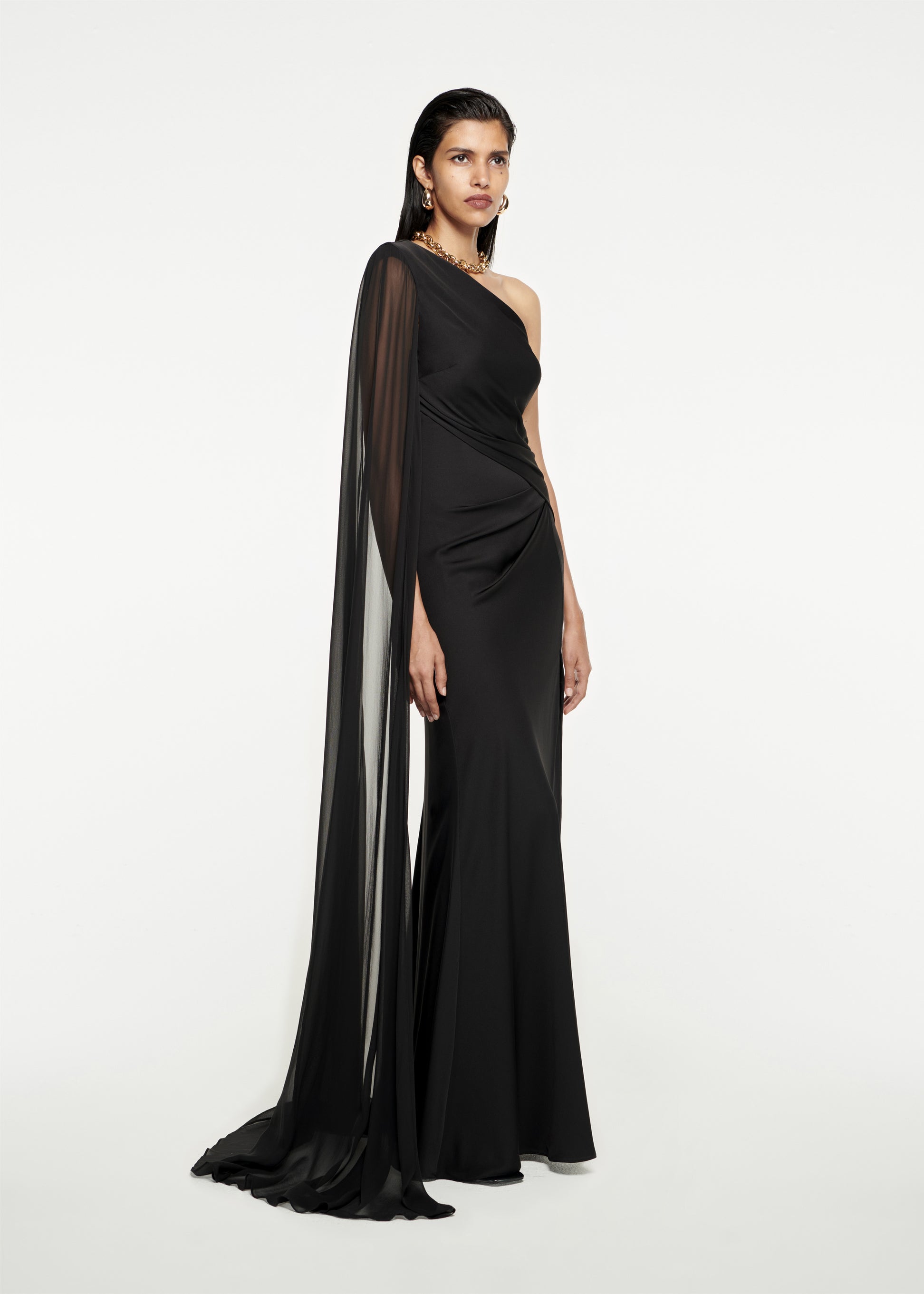 Woman wearing the Asymmetric Stretch Silk Crepe Gown in Black