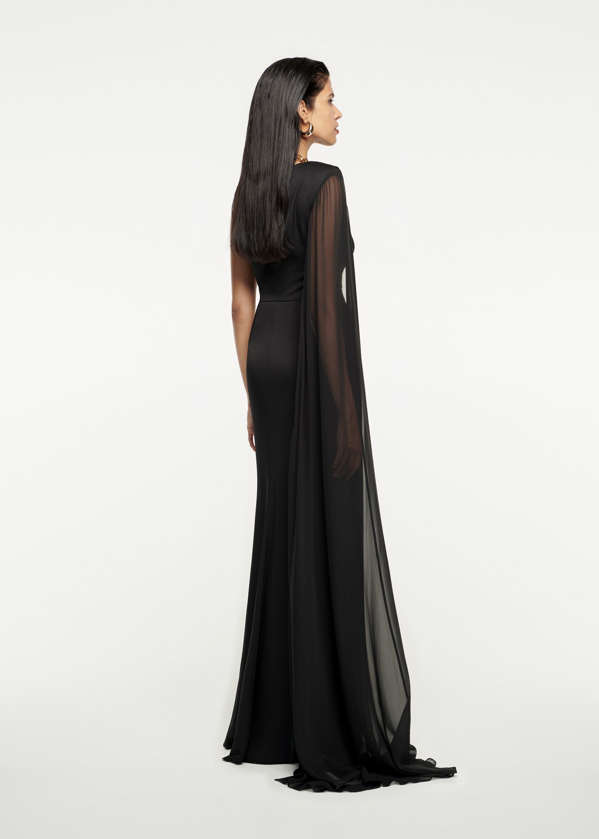 The back of a woman wearing the Asymmetric Stretch Silk Crepe Gown in Black