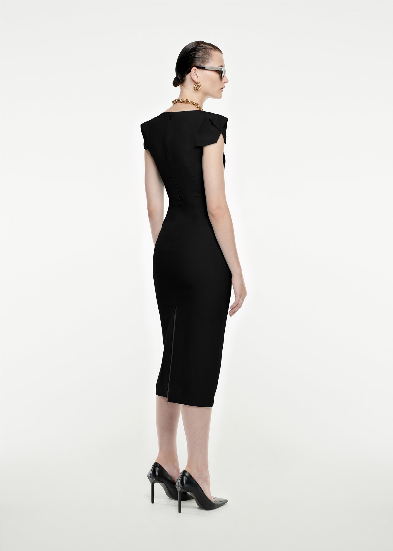 The back of a woman wearing the Cap Sleeve Silk Wool Midi Dress in Black