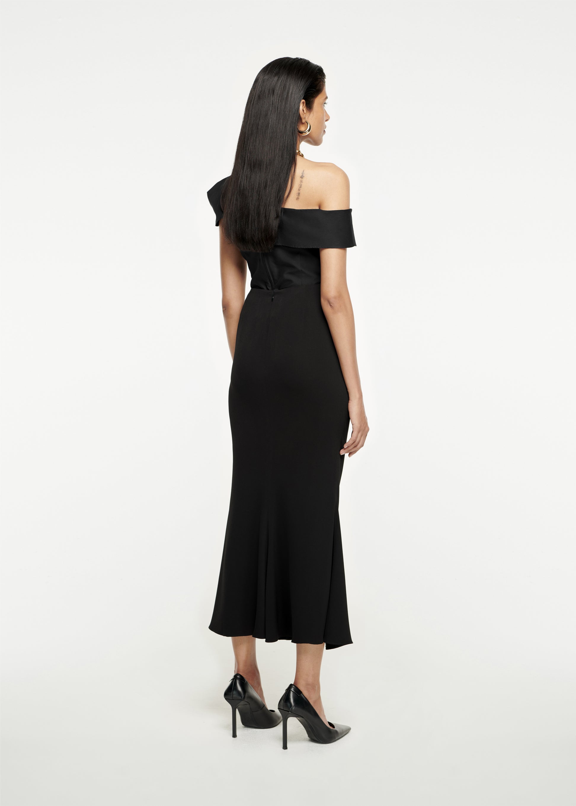 The back of a woman wearing the Asymmetric Stretch-Cady Top in Black